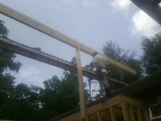 Carpenter setting a ridge beam over a new addition frame — Ice Dam Removal by Roofing Brothers in East Rockaway