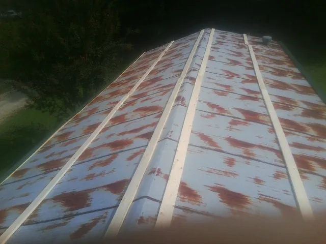 Rusted metal roof panels with new wood purlins before replacement — Storm Damage Roof Repair in East Rockaway by Roofing Brothers