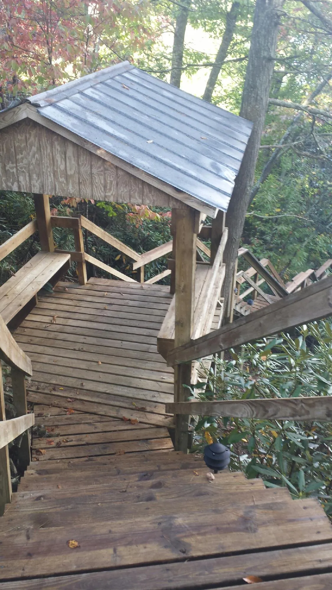 Metal roofed shelter over wooden steps on a wooded walkway — Skylight Repair & Installation work by our crew in East Rockaway